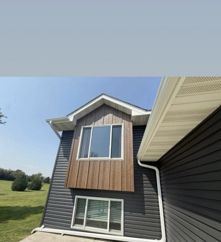Dark board and batten siding with new gutters — Becker Roofing St. Croix County WI